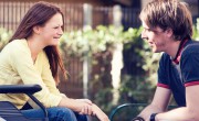 Girl in wheelchair chatting to boy with shaggy hair