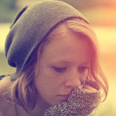 Young girl wearing a hat and looking unhappy