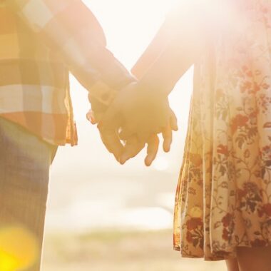 Couple holding hands at sunset