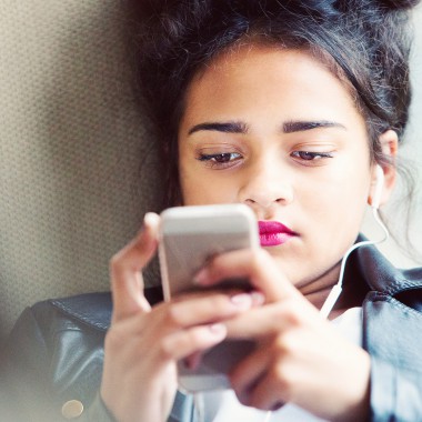 Girl looking at phone with headphones in