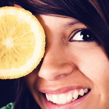 Girl with lemon covering her eye