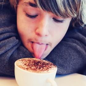 Boy licking cappucino