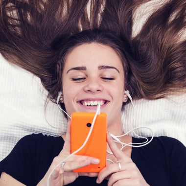 Girl lying on bed looking at phone