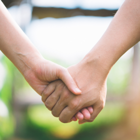 Adult holding young persons hand