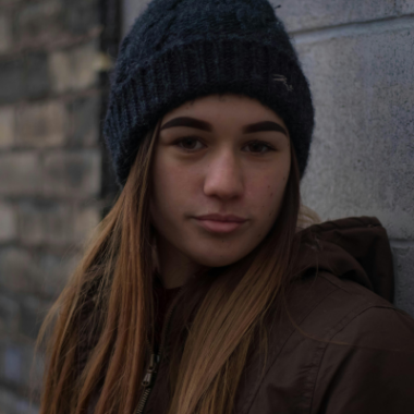 Girl with a woolly hat looking into the camera