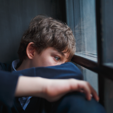 Sad boy looking out of window